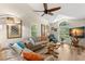 Cozy living room featuring vaulted ceilings, wood floors, a ceiling fan, and ample natural light at 13598 Park Blvd, Seminole, FL 33776