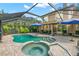 Beautiful kidney-shaped pool and spa with brick surround in a screened lanai with comfortable patio seating at 13598 Park Blvd, Seminole, FL 33776