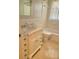 Bright bathroom with a marble-top vanity, tiled floors, and a shower-tub, creating a clean and functional space at 13725 Bermuda Dr, Seminole, FL 33776