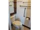 Cozy half bathroom with a toilet, a wooden shelfed mirror, and accessibility handrails at 13725 Bermuda Dr, Seminole, FL 33776