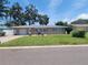Charming single-story home featuring a well-manicured lawn, a cozy outdoor dining area, and an attached garage at 13725 Bermuda Dr, Seminole, FL 33776