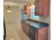 Well-lit kitchen featuring granite countertops, stainless steel appliances, wood cabinets and tile floors at 13725 Bermuda Dr, Seminole, FL 33776