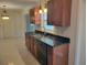Kitchen showcasing granite countertops, wood cabinets, a stainless steel sink, and tile floors at 13725 Bermuda Dr, Seminole, FL 33776