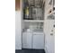 Bright laundry room featuring washer, dryer, hot water tank and overhead storage shelf at 13725 Bermuda Dr, Seminole, FL 33776