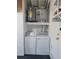 Bright laundry room featuring washer, dryer, hot water tank and overhead storage shelf at 13725 Bermuda Dr, Seminole, FL 33776