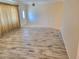 Open-concept living space with wood-style tile flooring and ample natural light from the front door at 13725 Bermuda Dr, Seminole, FL 33776