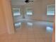Spacious living room with tile floors, ample natural light, and a ceiling fan at 13725 Bermuda Dr, Seminole, FL 33776