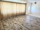 Bright living room with modern wood-style tile flooring and neutral decor, filled with natural light at 13725 Bermuda Dr, Seminole, FL 33776