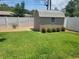 Backyard with a shed, green lawn, and white privacy fence at 13725 Bermuda Dr, Seminole, FL 33776