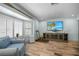 Cozy living room featuring a comfy blue couch, bay windows, and light wood-look floors at 1382 52Nd Ne Ave, St Petersburg, FL 33703