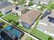 A lovely home features a screened-in lanai, pool, fenced yard, and solar panels on the neighboring home's roof at 13912 Painted Bunting Ln, Riverview, FL 33579