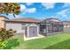 Landscaped backyard with a shed, screened-in patio, and lush green grass at 13912 Painted Bunting Ln, Riverview, FL 33579