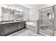 Elegant bathroom featuring dual sinks, a soaking tub, and a tiled glass shower at 13912 Painted Bunting Ln, Riverview, FL 33579