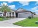Charming single-story home features a manicured lawn, mature landscaping, and an attached two-car garage at 13912 Painted Bunting Ln, Riverview, FL 33579