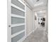 Bright hallway features a stylish sliding door, tile flooring, and access to various rooms at 13912 Painted Bunting Ln, Riverview, FL 33579