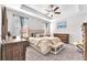 Comfortable main bedroom featuring soft lighting, a ceiling fan, and a neutral color palette at 13912 Painted Bunting Ln, Riverview, FL 33579