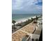 Aerial view of patio and beach with palm trees, ocean water and people enjoying the sun at 14950 Gulf Blvd # 603, Madeira Beach, FL 33708