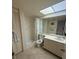 Bathroom with sink, mirror, shower, toilet, tile floor, linen closet and natural light from skylight at 14950 Gulf Blvd # 603, Madeira Beach, FL 33708
