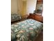 Bedroom with two beds, matching seashell bedding, and dresser at 14950 Gulf Blvd # 603, Madeira Beach, FL 33708
