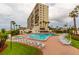 An in-ground pool and spa are surrounded by palm trees and lounge chairs for relaxing at 14950 Gulf Blvd # 603, Madeira Beach, FL 33708