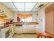 The kitchen features white appliances, cabinets, tile floors, and a pass-through to the living area at 14950 Gulf Blvd # 603, Madeira Beach, FL 33708