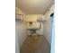 Walk-in laundry room with shelving, hanging rack, tile floor, ironing board and overhead lighting at 14950 Gulf Blvd # 603, Madeira Beach, FL 33708