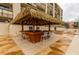 View of the beach community's tiki hut with a thatched roof, bar, and chairs for residents at 14950 Gulf Blvd # 603, Madeira Beach, FL 33708