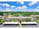 An aerial view of the property showing the building, covered parking, and a scenic pond surrounded by lush greenery at 172 Lakeview Way # 172, Oldsmar, FL 34677