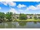 Picturesque view of the condo building from across the lake, surrounded by lush greenery and a serene landscape at 172 Lakeview Way # 172, Oldsmar, FL 34677