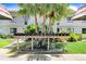 A row of mailboxes in front of a tropical condominium building with green grass and palm trees adds curb appeal at 172 Lakeview Way # 172, Oldsmar, FL 34677