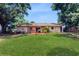 Rear of the house featuring a well-maintained lawn and an outdoor entertaining area at 1720 Chrysler Ave, Sarasota, FL 34234