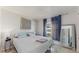 Bright bedroom featuring a queen-sized bed with a striped comforter, side table, window and mirror at 1720 Chrysler Ave, Sarasota, FL 34234