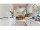 Bright kitchen with white cabinets, appliances, tile floors, and view into dining area at 1720 Chrysler Ave, Sarasota, FL 34234