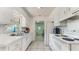Bright kitchen with white cabinets, tile backsplash, and stainless steel sink under a window at 1720 Chrysler Ave, Sarasota, FL 34234