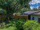 Landscaped backyard with privacy fence, shade trees, lush green grass and nearby neighbor at 18003 Arbor Crest Dr, Tampa, FL 33647