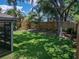 Spacious backyard featuring a well-manicured lawn, shade trees, and privacy fence at 18003 Arbor Crest Dr, Tampa, FL 33647