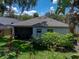 View of the home's backyard showing the screened in patio, well-manicured lawn and garden at 18003 Arbor Crest Dr, Tampa, FL 33647