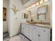 Spacious bathroom with double vanity, granite counters, decorative mirrors, and stylish lighting fixtures at 18003 Arbor Crest Dr, Tampa, FL 33647