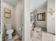 Elegant bathroom showcasing marble floors, a glass-enclosed shower, and ornate gold mirror and sconce at 18003 Arbor Crest Dr, Tampa, FL 33647