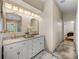 Elegant bathroom with double vanity, marble tile flooring, decorative mirrors, and a glimpse into the bedroom at 18003 Arbor Crest Dr, Tampa, FL 33647