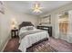 Cozy bedroom with soft carpet, ceiling fan, decorative mirror, and a window with natural light at 18003 Arbor Crest Dr, Tampa, FL 33647