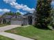 Charming one-story home with well-manicured lawn, mature landscaping, and a two-car garage at 18003 Arbor Crest Dr, Tampa, FL 33647