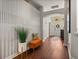Stylish hallway with hardwood floors, a decorative wall, and an orange cushioned bench at 18003 Arbor Crest Dr, Tampa, FL 33647