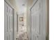 Hallway with marble floors and white doors, leading to a bedroom with neutral color palette at 18003 Arbor Crest Dr, Tampa, FL 33647