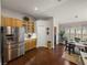 Bright kitchen with stainless steel refrigerator, natural wood cabinets, and a view to the dining area at 18003 Arbor Crest Dr, Tampa, FL 33647