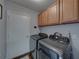 Efficient laundry room with modern washer and dryer, plus overhead storage at 18003 Arbor Crest Dr, Tampa, FL 33647