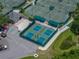 Aerial view of the pickleball courts with green fencing, and the surrounding trees and parking lot at 18003 Arbor Crest Dr, Tampa, FL 33647