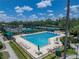 Aerial view of the lap swimming pool with covered lounge areas and tennis courts, perfect for recreational activities at 18003 Arbor Crest Dr, Tampa, FL 33647