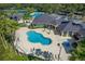 Aerial view of the lagoon pool and clubhouse featuring shaded seating and manicured grounds in a vibrant community setting at 18003 Arbor Crest Dr, Tampa, FL 33647