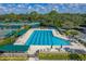 Lap swimming pool with surrounding tennis courts and verdant landscaping; an ideal spot for both relaxation and recreation at 18003 Arbor Crest Dr, Tampa, FL 33647